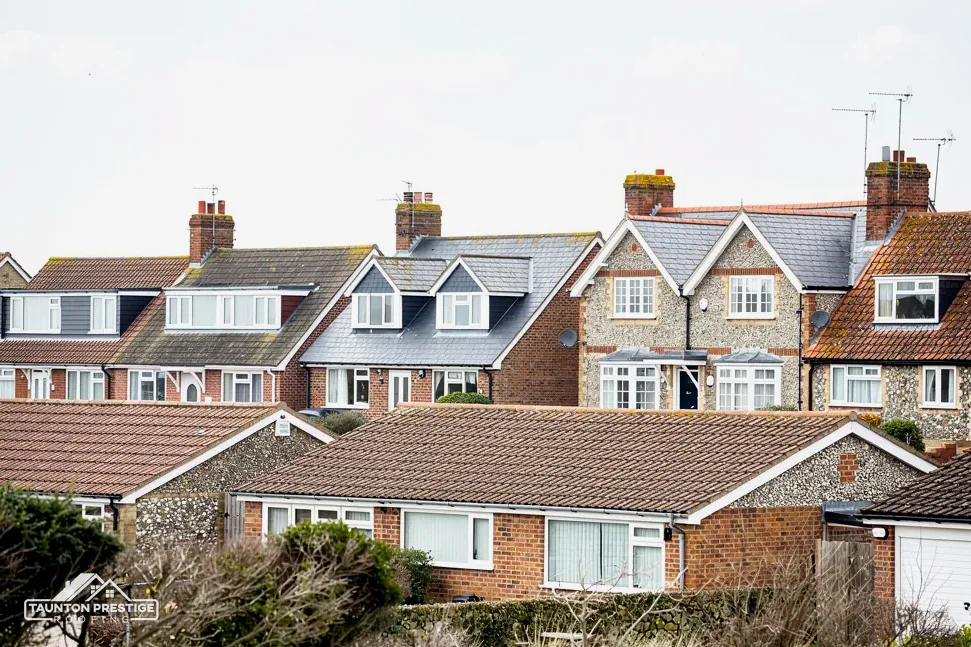 Rooftops of brick and flint houses with tiled roofs and chimneys
