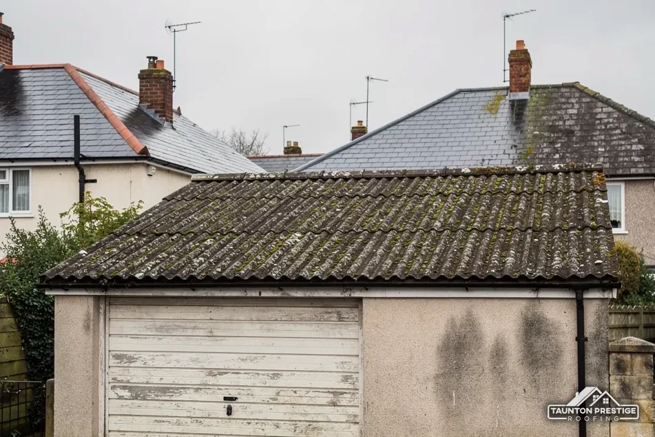 Detached garage with an old corrugated sheet roof covered in moss and lichen