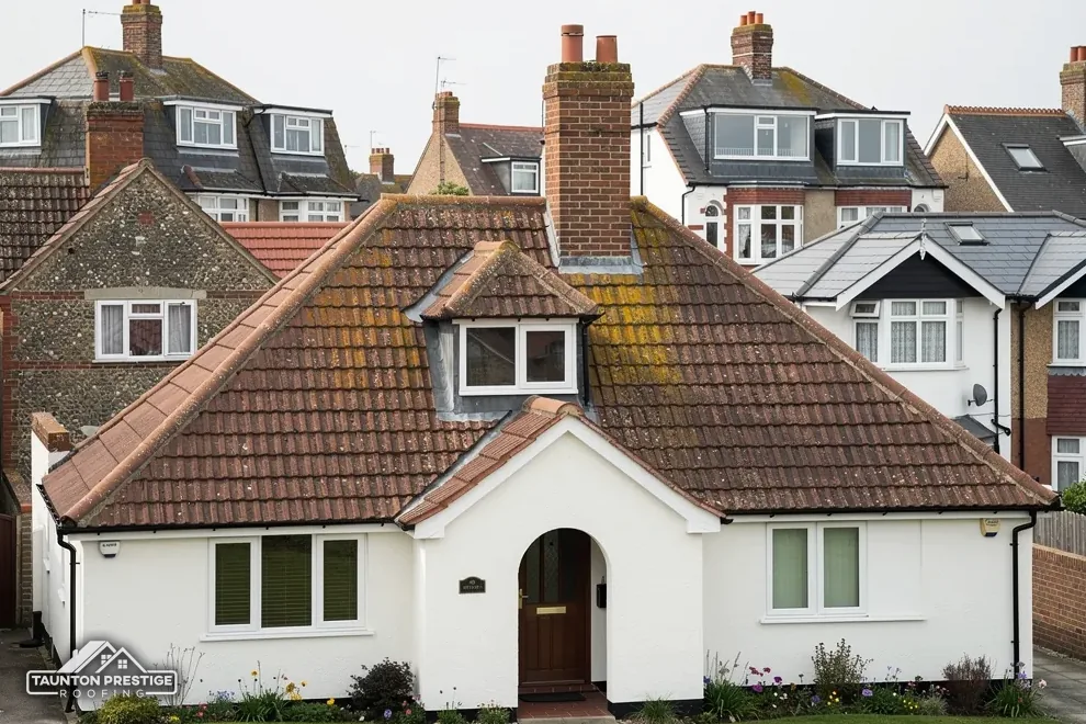 Interwar bungalow with a clay tile roof, a small dormer and an arched porch
